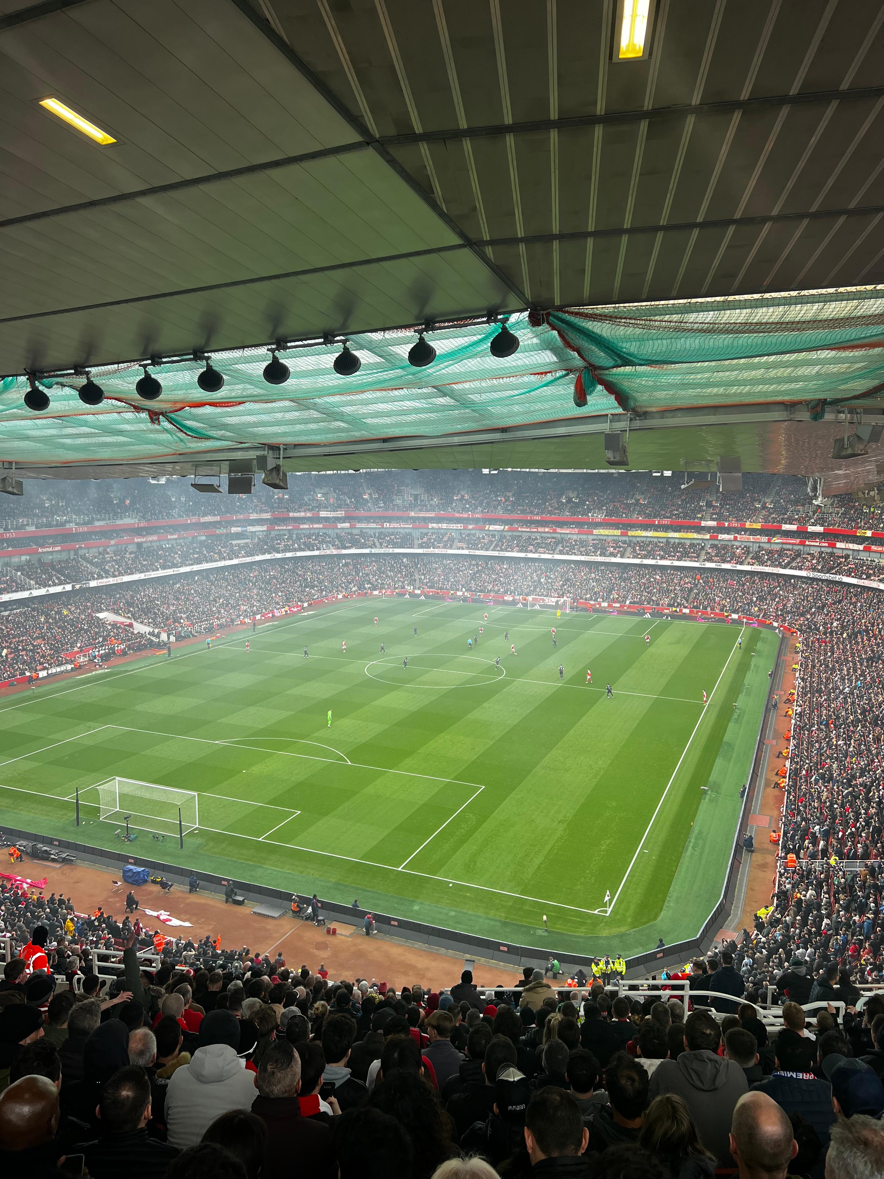 Emirates Stadium inside view during Arsenal match packed crowd upper tier perspective pitch.