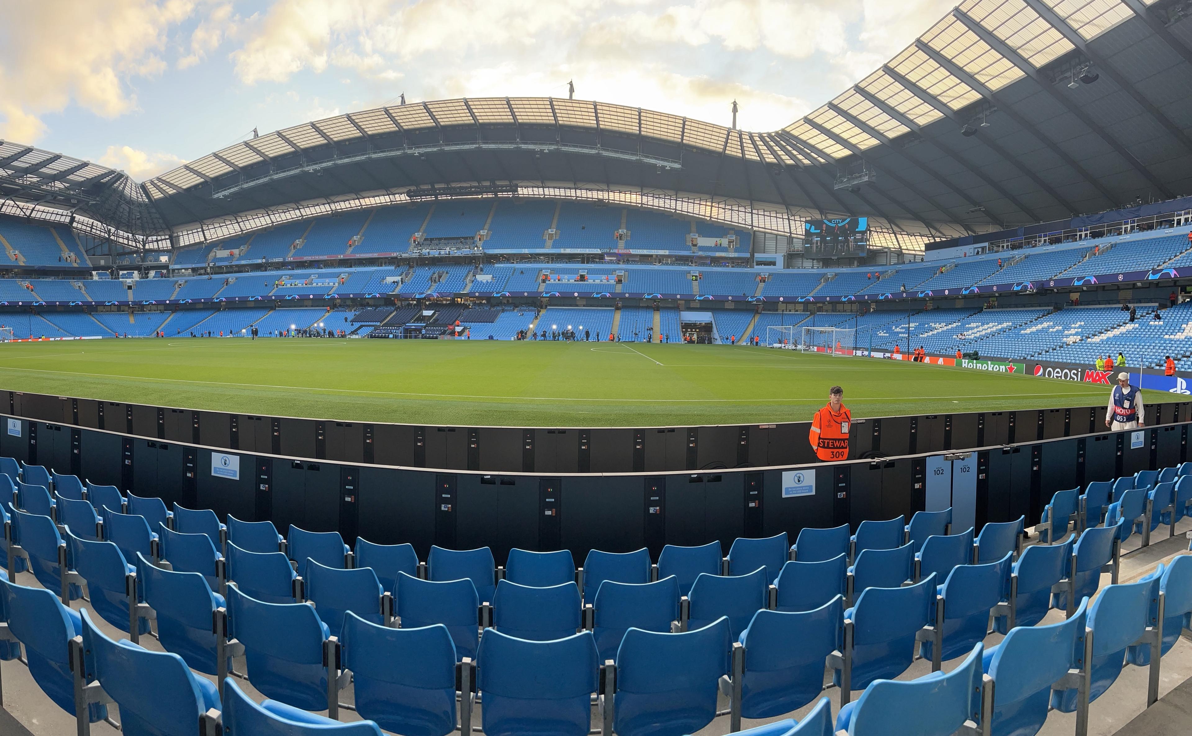 Etihad Stadium inside panoramic view Manchester City pitch blue seats roof structure