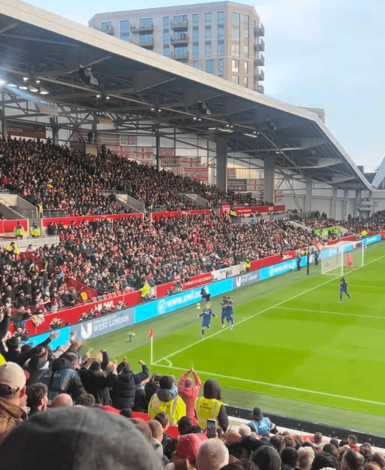 Away fans celebrating a goal in the northeast corner of the Gtech Community Stadium.