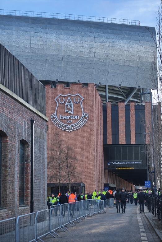 The outside of Hill Dickinson Stadium with the Everton crest as fans walk toward the entrances.