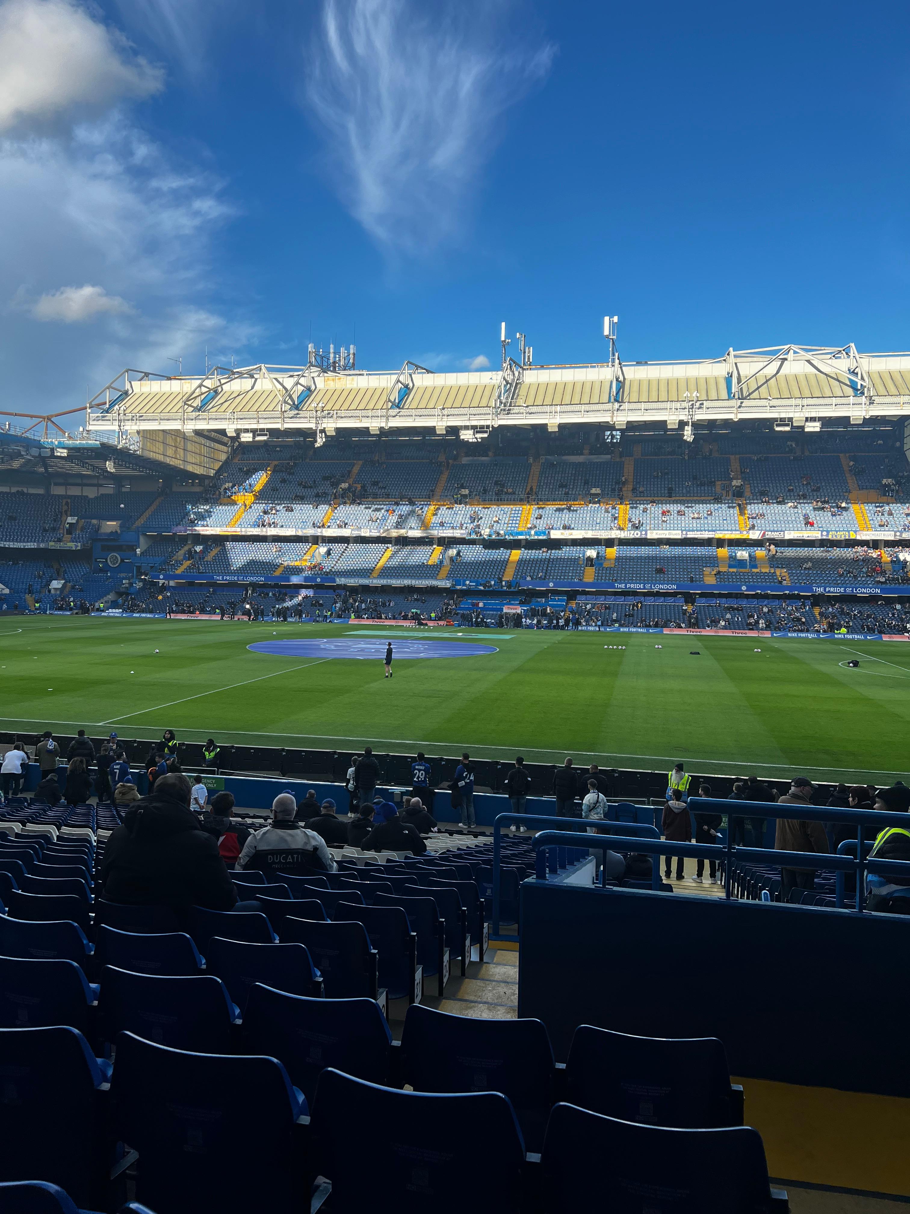 Stamford Bridge inside view Chelsea FC pitch and stands Pride of London banners blue seats Premier League matchday