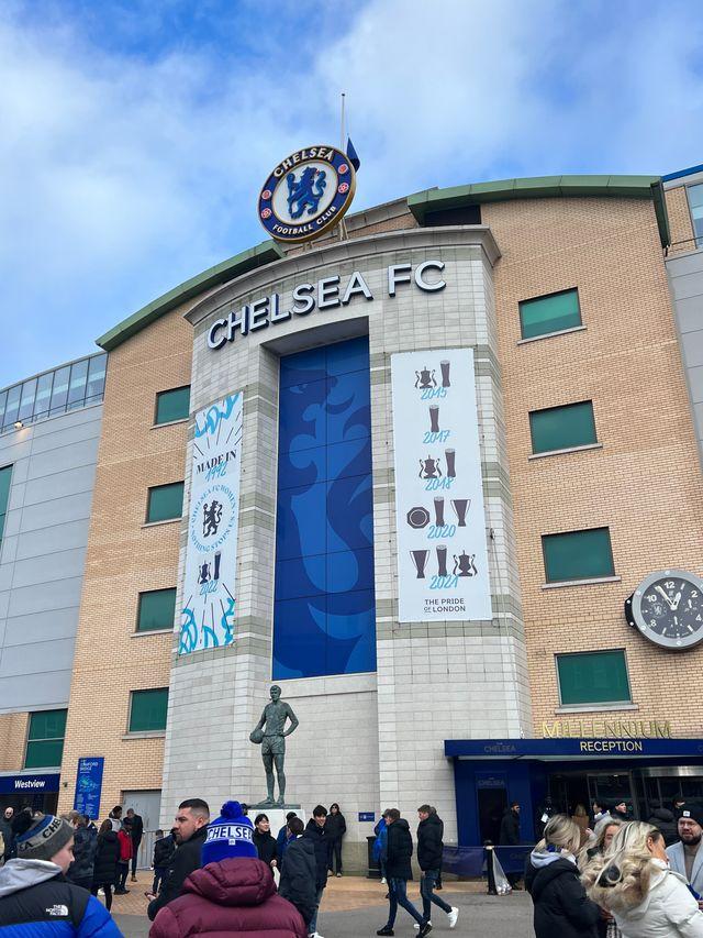 Stamford Bridge main entrance Chelsea FC crest Peter Osgood statue Millennium Reception trophy banners fans matchday London