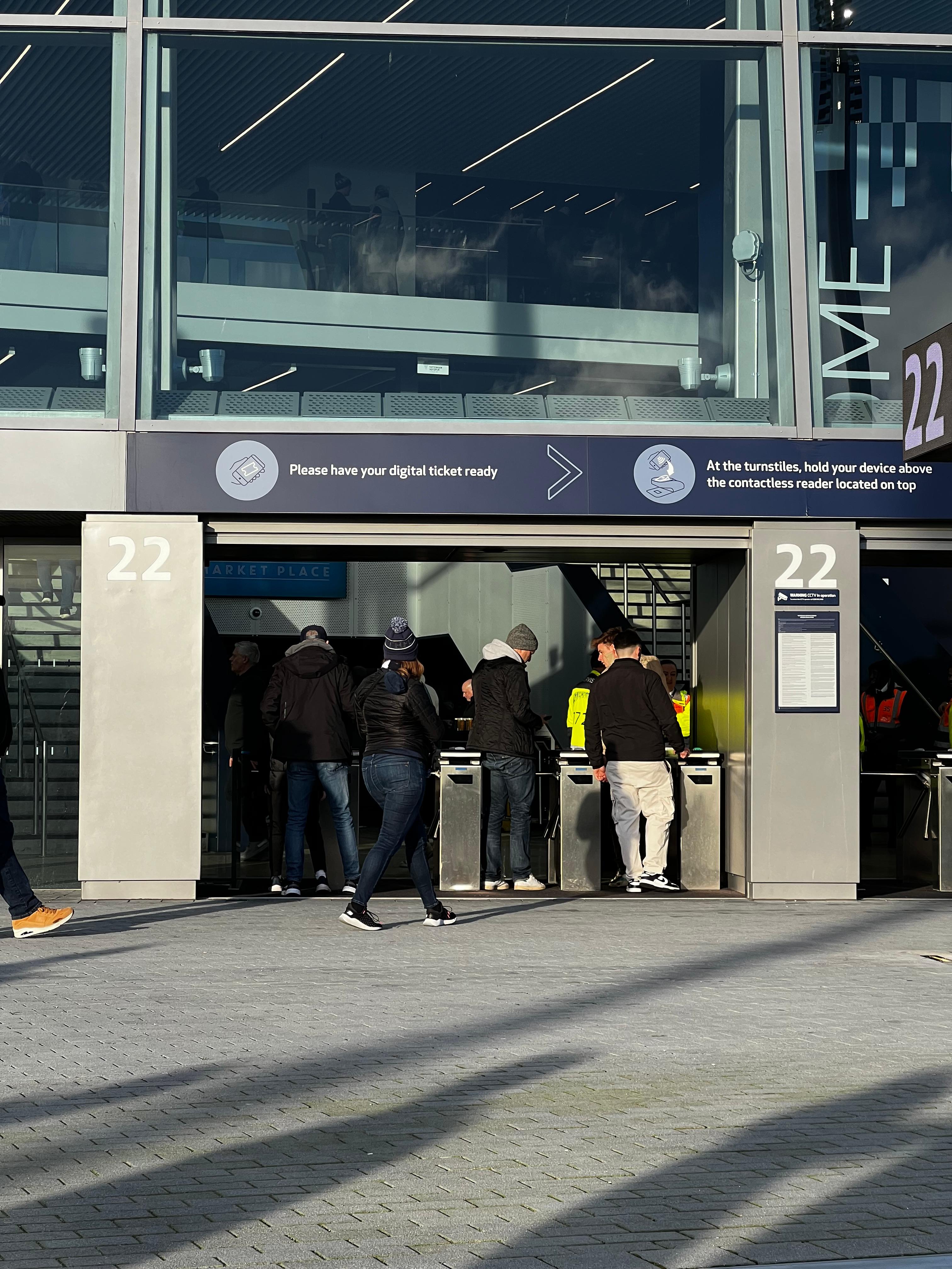 Fans entering Tottenham Hotspur Stadium through turnstiles